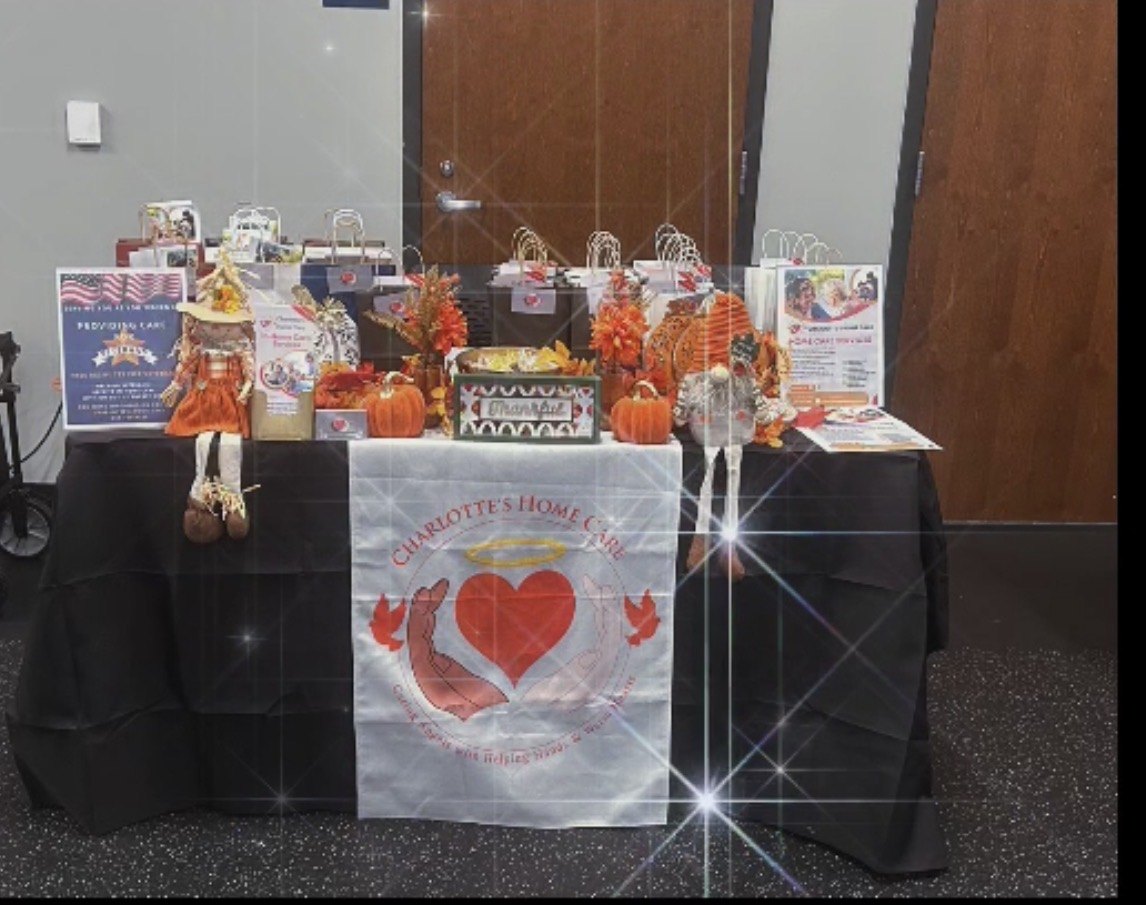 The Charlotte's Home Care table at a community event, with gift bags, flyers and autumn decorations