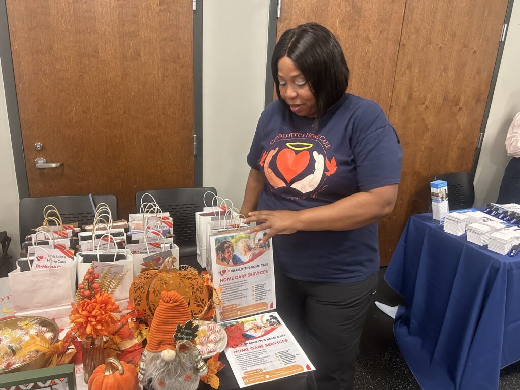 A Charlotte's Home Care team member setting out gift bags and brochures at a community event
