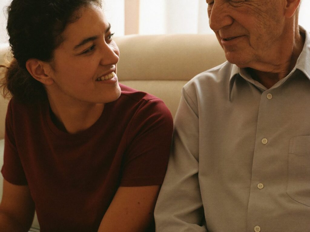 A caregiver and an older man sitting together in conversation